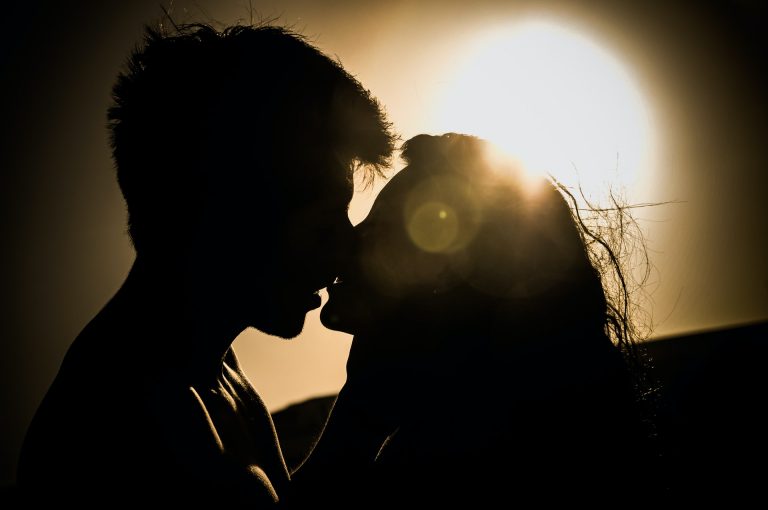 a silhouette of a man and woman kissing