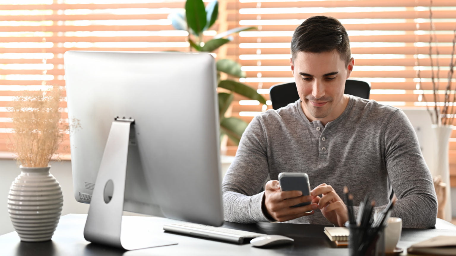 man sitting at home office and using smart phone.